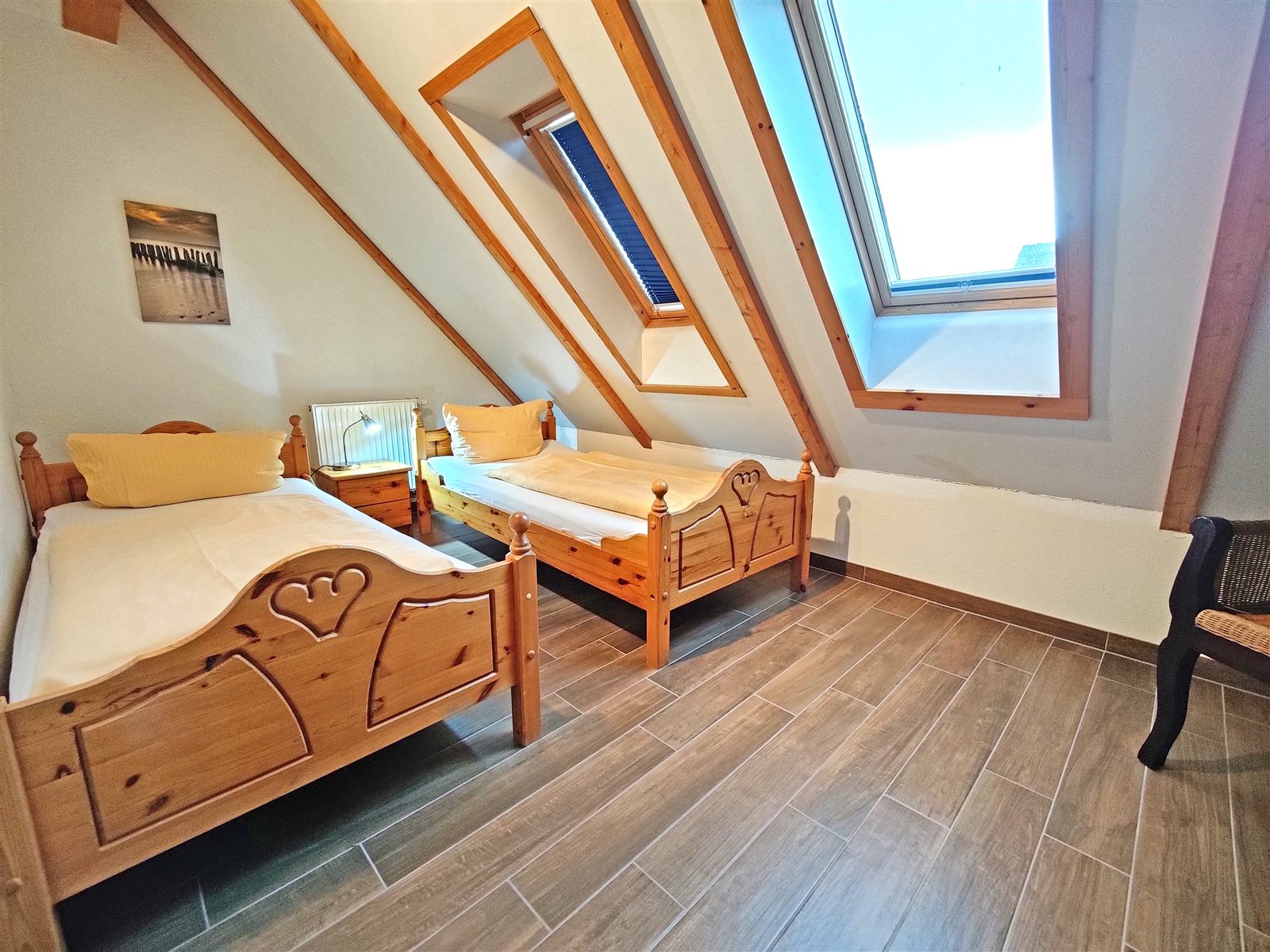 Schlafzimmer im Dachgeschoss mit zwei Einzelbetten und Dachfenstern
